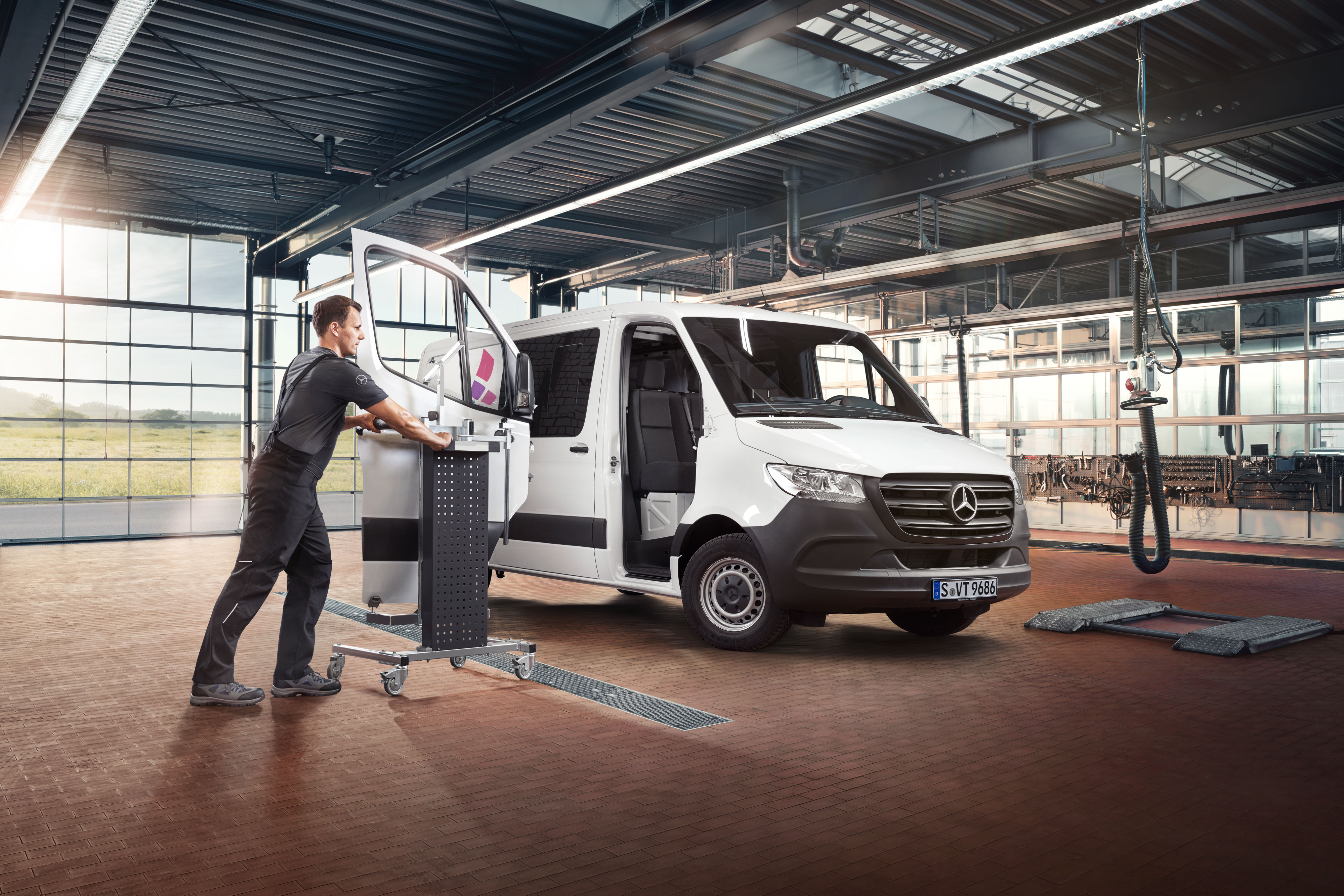 Mercedes-Benz | Reparatur Mechaniker beim Einbau der Tür eines weißen Mercedes-Benz Sprinter.