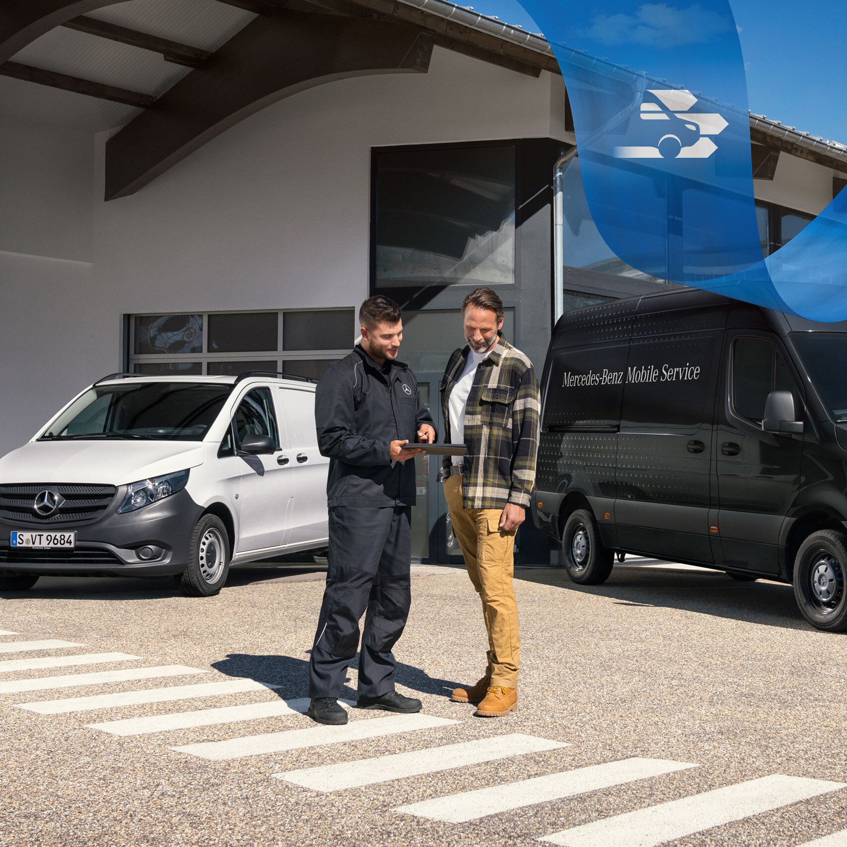 Zwei Männer unterhalten sich vor einem weißen Mercedes-Benz Vito und einem schwarzen Mercedes-Benz Sprinter.